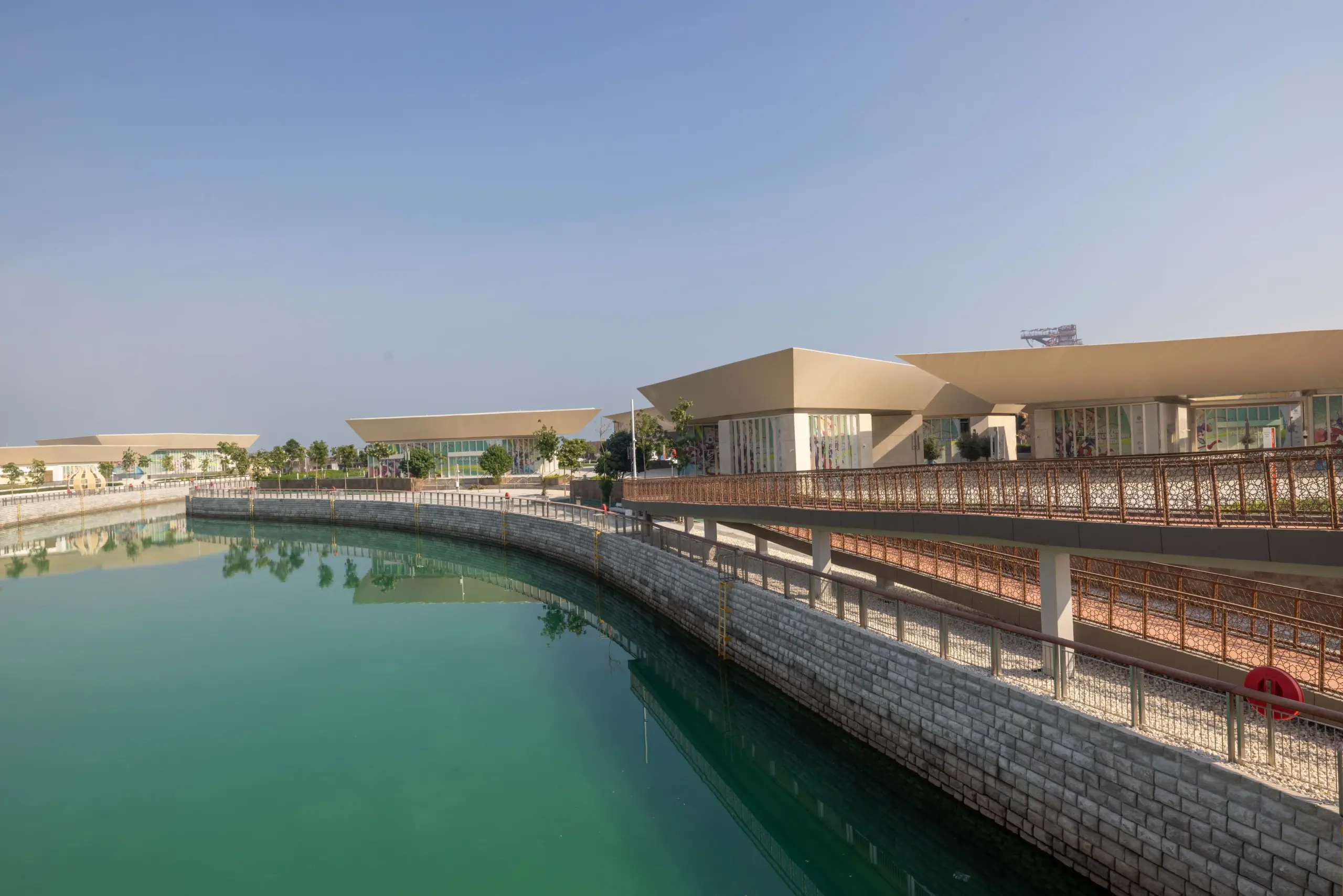 Retail and F&B plazas on Qetaifan Island North, showing modern angular buildings along the Majra Alsail canal with outdoor dining and pedestrian promenades